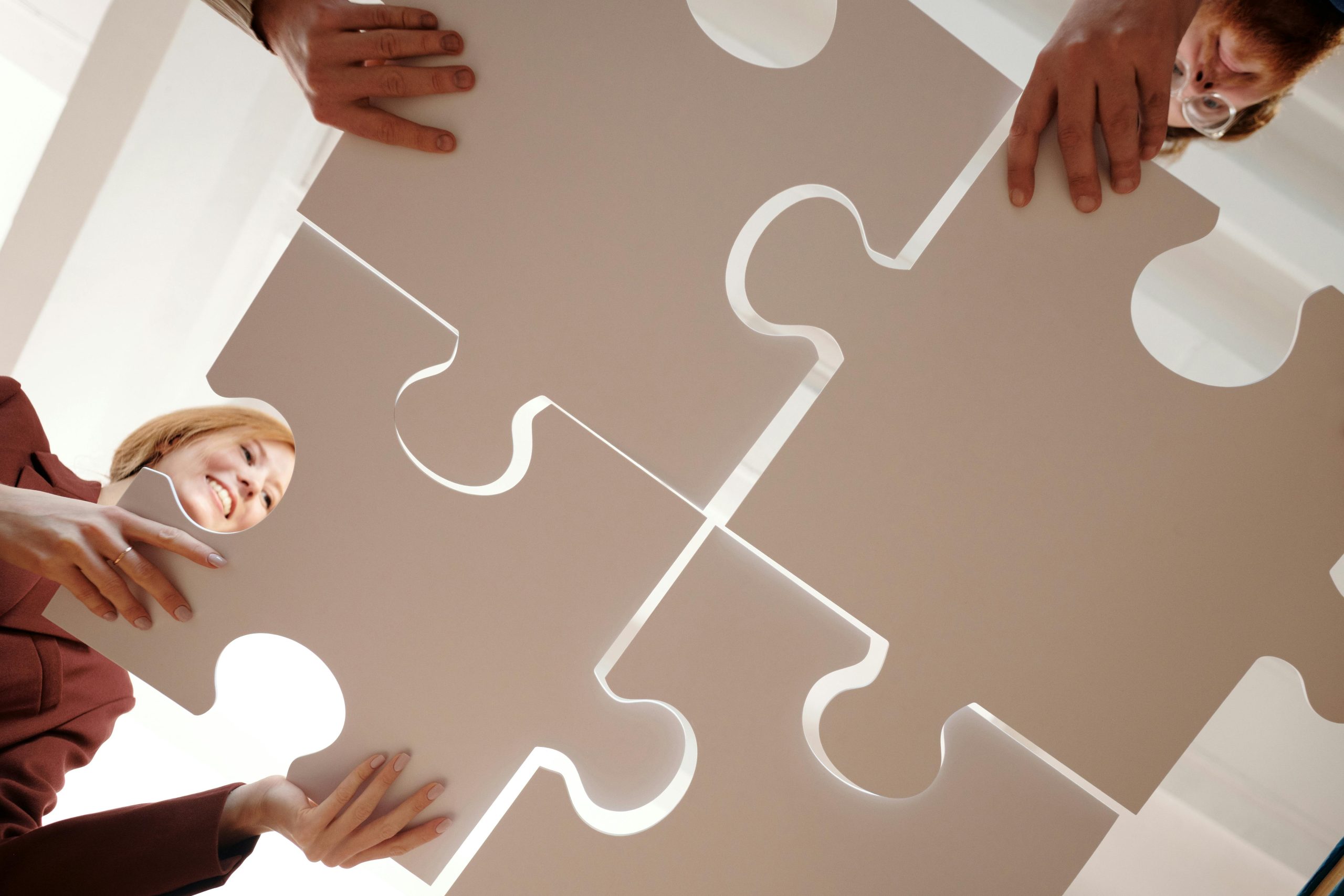 Hands fitting puzzle pieces together