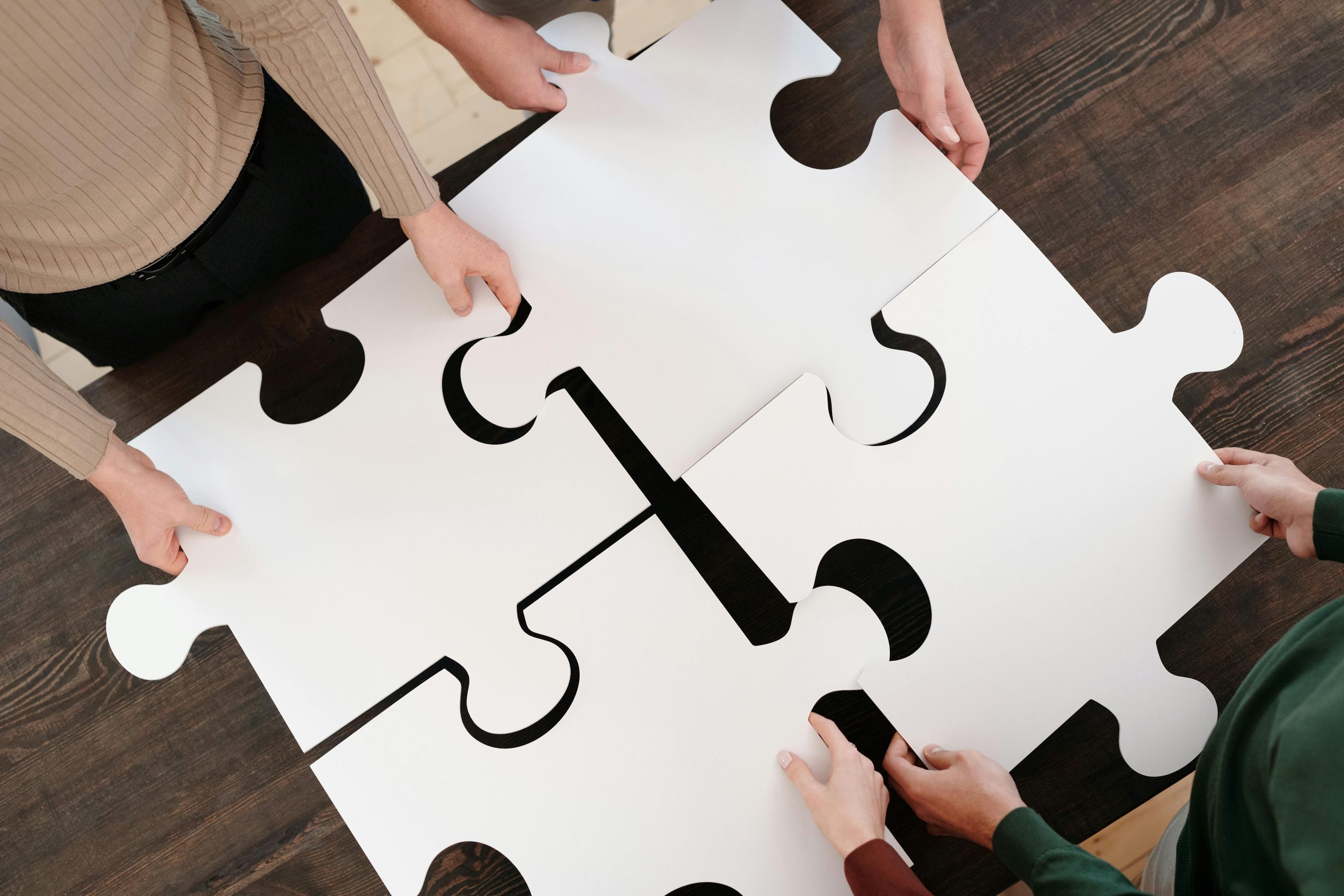 Hands joining large puzzle pieces