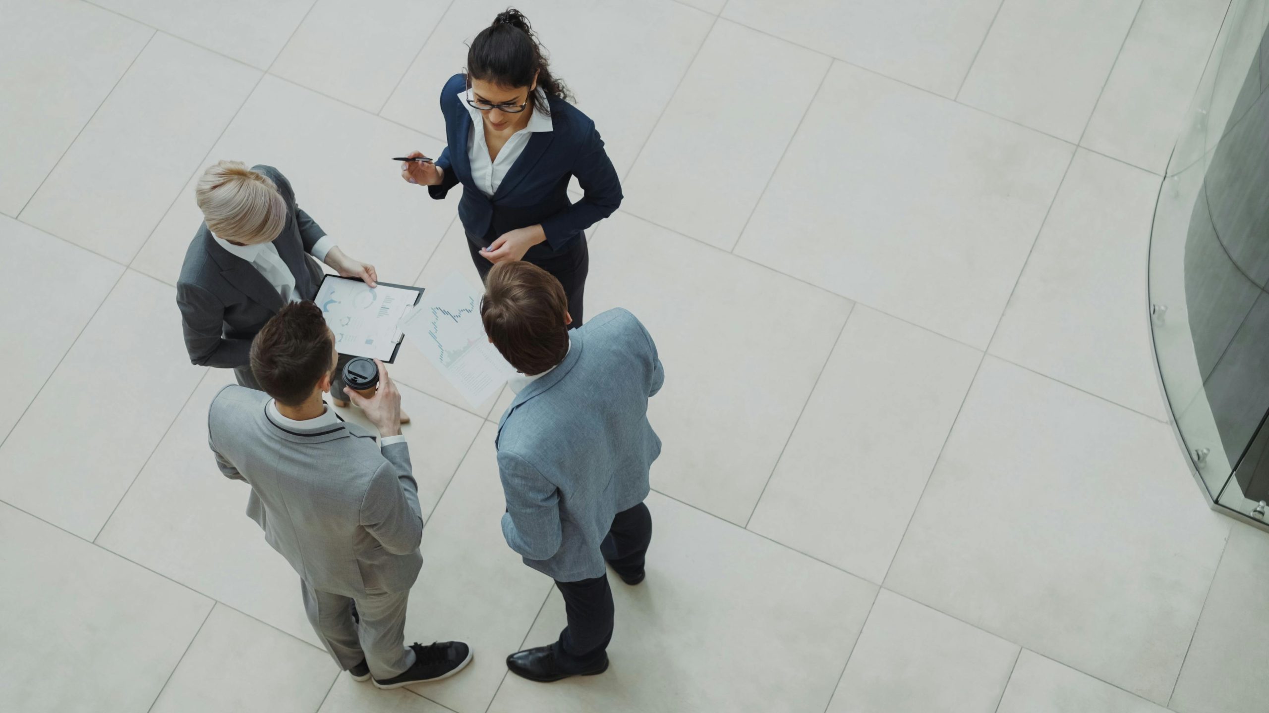 Colleagues talking in a bright lobby, seen from above
